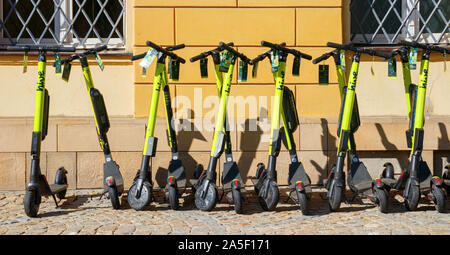 Scooter elettrici (E-scooter) da alveare per la condivisione di scooter parcheggiato in una fila vicino a una parete. Wroclaw, Polonia. Foto Stock