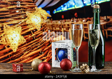 Champagne in bicchieri e in una bottiglia. Natale romantico sfondo. Nelle vicinanze si trova un giocattolo di Natale. luogo per il testo Foto Stock