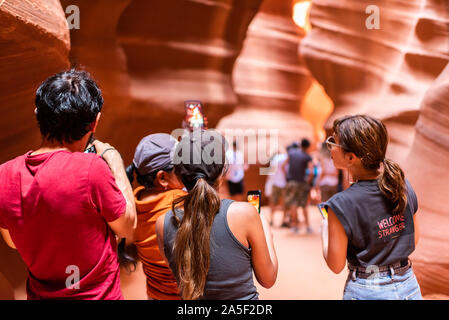 Pagina, Stati Uniti d'America - 10 agosto 2019: Navajo Tribal tours di gruppo giovani standing superiore interno slot Antelope Canyon in Arizona a scattare foto di strette tr Foto Stock