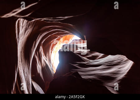 Basso angolo vista di ombre scure e la luce del cielo in upper Antelope Canyon slot con forma d'onda roccia arenaria nella pagina, Arizona Foto Stock