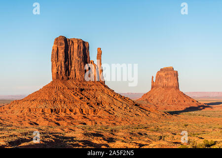 Vista della famosa mesa formazioni butte closeup con arancia rossa roccia di colore su orizzonte in Monument Valley canyon durante il tramonto in Arizona Foto Stock