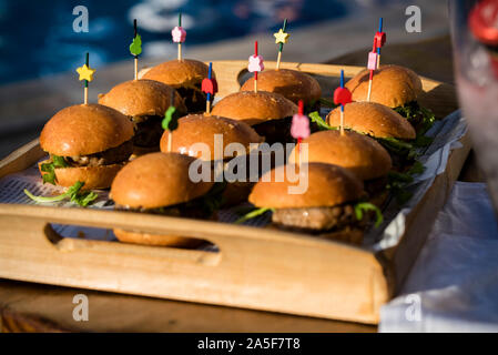 Chiusura del gruppo di mini hamburger su un piatto della festa di nozze o cotte - delizioso piccolo hamburger americano Foto Stock