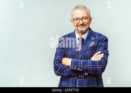 Ritratto di un imprenditore maturo indossando occhiali su sfondo bianco. Felice l'uomo senior guardando la telecamera isolata parete bianca con copia spazio. Close up Foto Stock