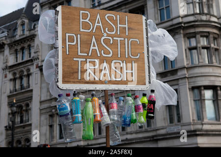 La protesta di plastica Londra UK 2019. Robert senza marca dimostra in Westminster, tenendo in mano un Bash immondizia di plastica poster segno, con un utilizzo di bottiglie in plastica e sacchetti di plastica appeso. Inghilterra 2010s. HOMER SYKES Foto Stock