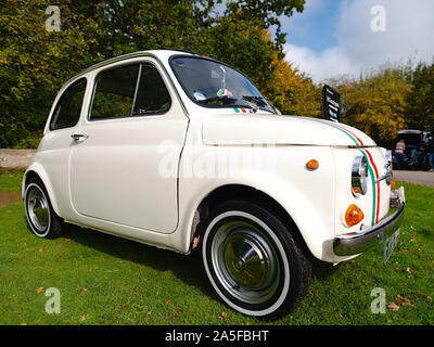 Fiat 500. Un classico 500 Fiat Cinquecento parcheggiata sul verde, ha bandiera italiana di colori Foto Stock