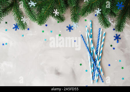 Le Cannucce con vari pattern in colore blu per il Natale o la festa di Capodanno. Sfondo di natale con accessori di festa per bevande e rami di abete. Chris Foto Stock