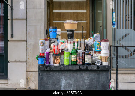 Spazzatura bilanciato su arredo urbano dopo la manifestazione di protesta nel centro di Londra. Takeaway tazze da caffè, lattine di birra e bottiglie e rapida di contenitori per alimenti. Foto Stock