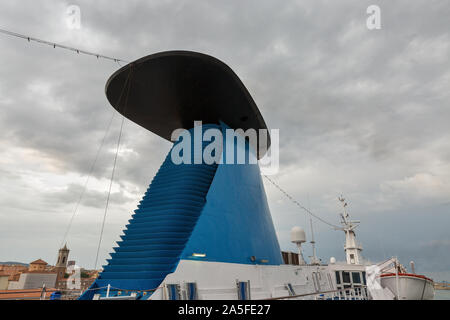 La nave di crociera tubo closeup contro il Livorno cityscape e sfondo con cielo nuvoloso, Italia. Foto Stock