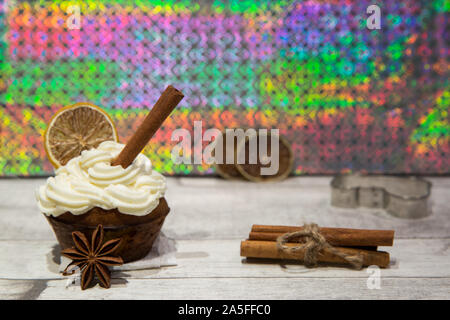 Holiday cupcake con glassa di mascarpone, essiccate di agrumi, arancio, limone e decorazione di calce, cookie cutter, cimmanon rotoli e anice stelle. Luminose colo Foto Stock