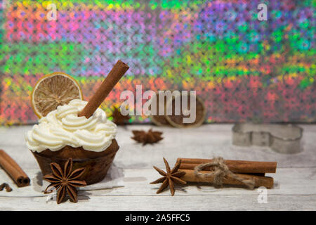 Holiday cupcake con glassa di mascarpone, essiccate di agrumi, arancio, limone e decorazione di calce, cookie cutter, cimmanon rotoli e anice stelle. Luminose colo Foto Stock