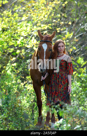 Bel paese ragazza bareback cavalcare il suo cavallo in autunno country road al tramonto Foto Stock