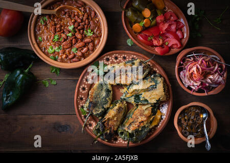 Chilles rellenos servita nei tradizionali piatti messicani, servito con fagioli, sottaceti Foto Stock