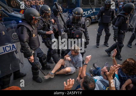 Una pacifica indipendenza protester seduto a terra è di essere stati sfrattati dalla polizia catalana durante la dimostrazione.il sesto giorno di protesta dopo l'annuncio delle sentenze da parte della Corte suprema di Spagna che condanna il catalano e i leader politici a lunghe pene detentive. Il agenti antisommossa hanno ripetutamente caricato i manifestanti intorno della stazione centrale di polizia della polizia nazionale in Via Laietana. Foto Stock