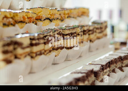 Assortimento di pezzi di torta sul tavolo disordinato, copia dello spazio. Più fette di deliziosi dessert, il menu del ristorante concetto, vista dall'alto. Foto Stock