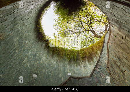 La scala a chiocciola di attraversamento sotterraneo nel tunnel a Fort Canning Park, Singapore. Foto Stock