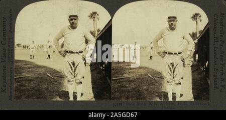 Babe Ruth, re di Swat, a San Pietroburgo, Florida. George Herman "" Babe Ruth, piena lunghezza, in piedi, rivolto verso la parte anteriore; indossa uniformi da baseball; in campo con le mani sui fianchi; gli altri giocatori in background. Foto Stock