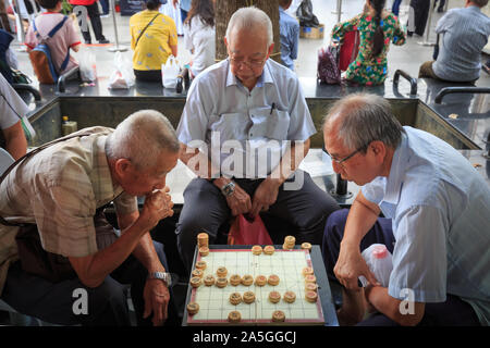 Singapore-09 giu 2018:cinese di vecchio uomo giocare a scacchi tradizionali in Singapore China town plaza aperta Foto Stock