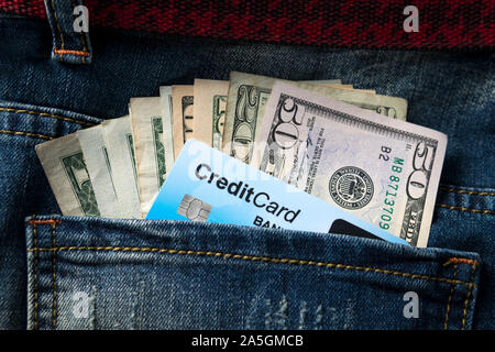 Dollaro americano banconota e la carta di credito in una delle tasche di jeans close up Foto Stock