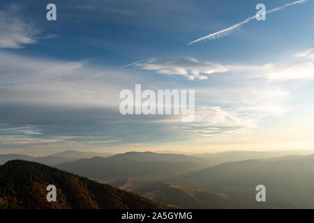 Bel tramonto e stratificata mountain sagome in serata. Autunno in montagna, un paesaggio fantastico Foto Stock