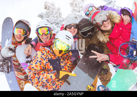 Grande gruppo di amici si diverte a ski resort. Felice gli sciatori e gli snowboarder sono prendendo foto insieme Foto Stock