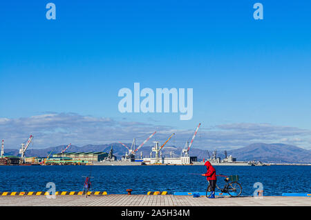 Dicembre 2, 2018 Hakodate, Giappone - Hakodate blu baia del porto con persone di pesca e porto industriale con grandi gru e nave mountain view sfondo, di Foto Stock