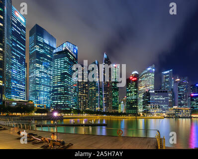 Singapore-30 APR 2018: Singapore il distretto centrale degli affari, vista di tutta la baia di Marina di notte con acqua di riflessione. Foto Stock