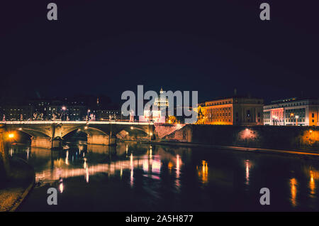 Vista notturna di Roma.In primo piano il fiume Tevere e il suo incredibile ponti e sullo sfondo la cupola della basilica di San Pietro. Foto Stock