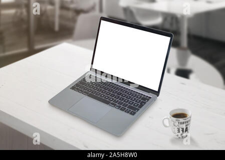 Mockup laptop sulla scrivania in ufficio con tazza di caffè accanto a. Foto Stock