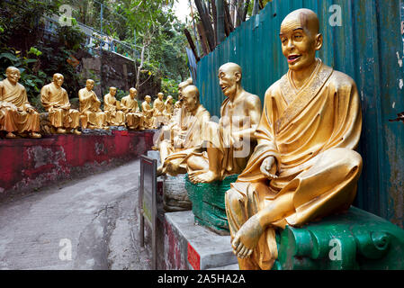 Statue di arhats (buddista equivalente di santi) sulla strada per il Monastero dei Diecimila Buddha (l'uomo grasso Sze). Sha Tin, Nuovi Territori di Hong Kong. Foto Stock