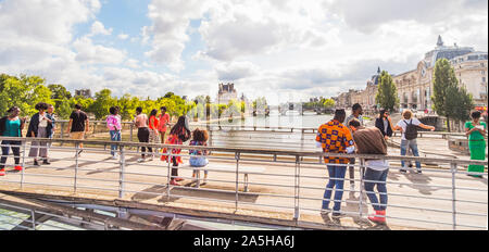 I giovani su Léopold-Sédar-Senghor passerella con il Louvre e il museo d' Orsay in background Foto Stock