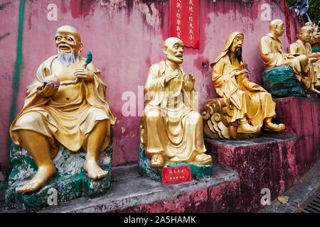 Statue di arhats (buddista equivalente di santi) sulla strada per il Monastero dei Diecimila Buddha (l'uomo grasso Sze). Sha Tin, Nuovi Territori di Hong Kong. Foto Stock