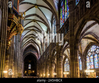 Lungo la navata e il coro della cattedrale di Notre Dame a Strasburgo, Francia, illuminato dalla luce solare con la sospensione di organi della tubazione sulla sinistra. Foto Stock