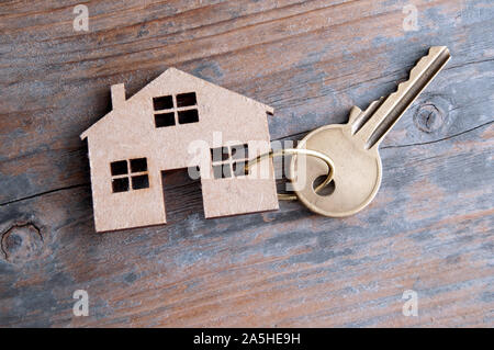 Chiave attaccata a una miniatura casa in legno Foto Stock