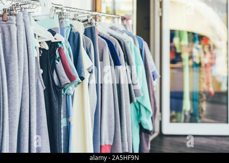 Nello showroom, cose semplici appendere in una fila su appendiabiti. Foto Stock