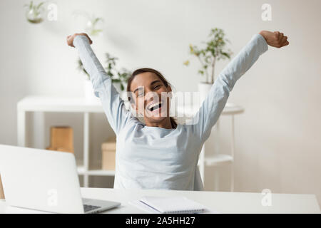 Overjoyed sorridente giovane razza mista lady rilassante dopo il progetto di finitura. Foto Stock