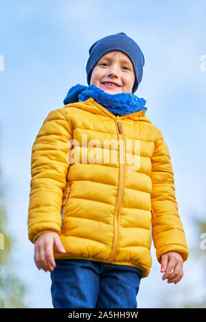 Bambino felice ragazzo giocando fuori in autunno Foto Stock