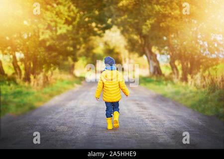 Bambino felice ragazzo giocando fuori in autunno Foto Stock