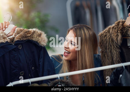 Le donne in età adulta shopping per i vestiti in boutique in autunno Foto Stock