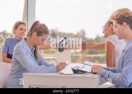 Persone sedute, di cui tre donne e due di essi sono di indossare le cuffie con i computer di fronte. Foto Stock