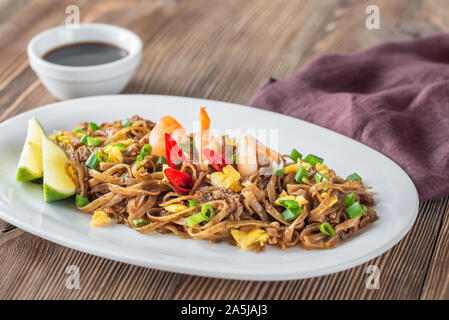 Piatto di Pad Thai - Thai fried rice noodles sullo sfondo di legno Foto Stock