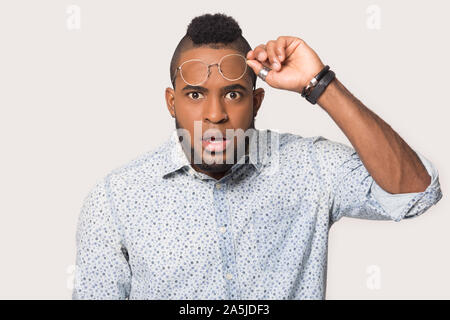 Scioccato biracial uomo guardare fotocamera sorpreso da news Foto Stock