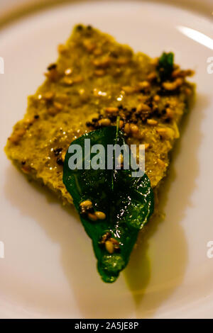 Dhokla è un cibo vegetariano voce che proviene da lo stato indiano del Gujarat. Esso è realizzato con un impasto fermentato derivato da riso e split chic Foto Stock
