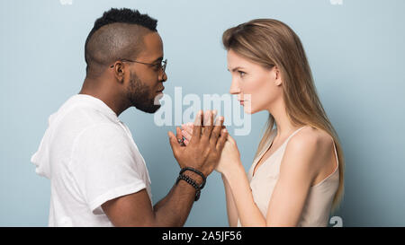 Multietnica giovane tenere mani di condividere momenti intimi insieme Foto Stock