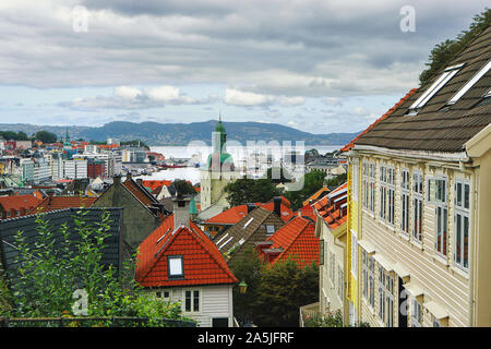 Bellissima vista di Bergen in tarda estate. Bergen Domkirke cattedrale, montagne, nuvole, porto, tradizionali case di legno con tetti di tegole. Hordaland, Foto Stock