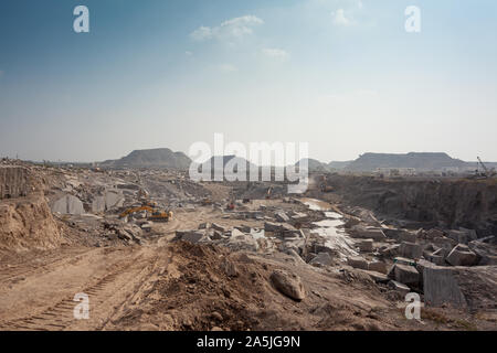 Vista grandangolare di una grande cava di granito galassico nero all'aperto. Una strada lo attraversa per la rimozione del sovraccarico. Ongole, Andhra Pradesh, india Foto Stock