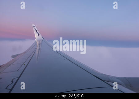 Irlandese Ryanair a basso costo aerei di compagnie aeree, wingtip con logotipo e tramonto dietro. Foto Stock