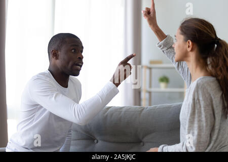 Arrabbiato multietnica giovane urlare sostenendo a casa Foto Stock