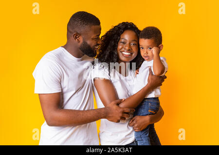 Ritratto di felice africana di genitori con il loro figlio sulle mani Foto Stock