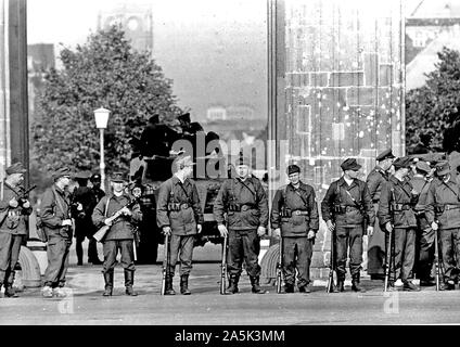 Agosto 1961 - Una squadra di Berlino est " lavoratori " di milizia con dei mitra sorge Shoulder-To-spalla davanti alla Porta di Brandeburgo. Dietro di loro, bloccando il passaggio, è un comunista Portavalori Foto Stock