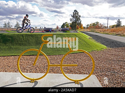 Giovani motociclisti navigare i loro veicoli su una pista a una bicicletta e skate park a Redmond, Oregon Foto Stock